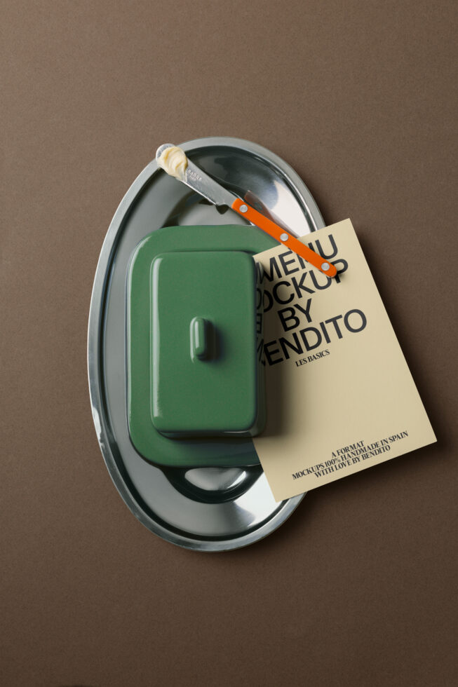 Green kitchenware container on metal plate with orange knife, cream tag