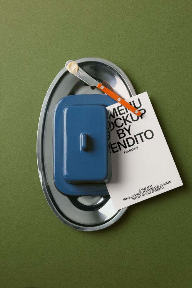 Blue kitchenware container on metal plate with orange knife, cream tag