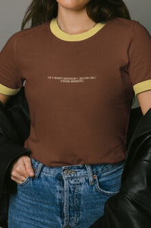 Brown ringer tee with yellow trim worn with blue jeans, black leather jacket