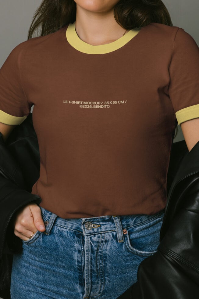 Brown ringer tee with yellow trim worn with blue jeans, black leather jacket