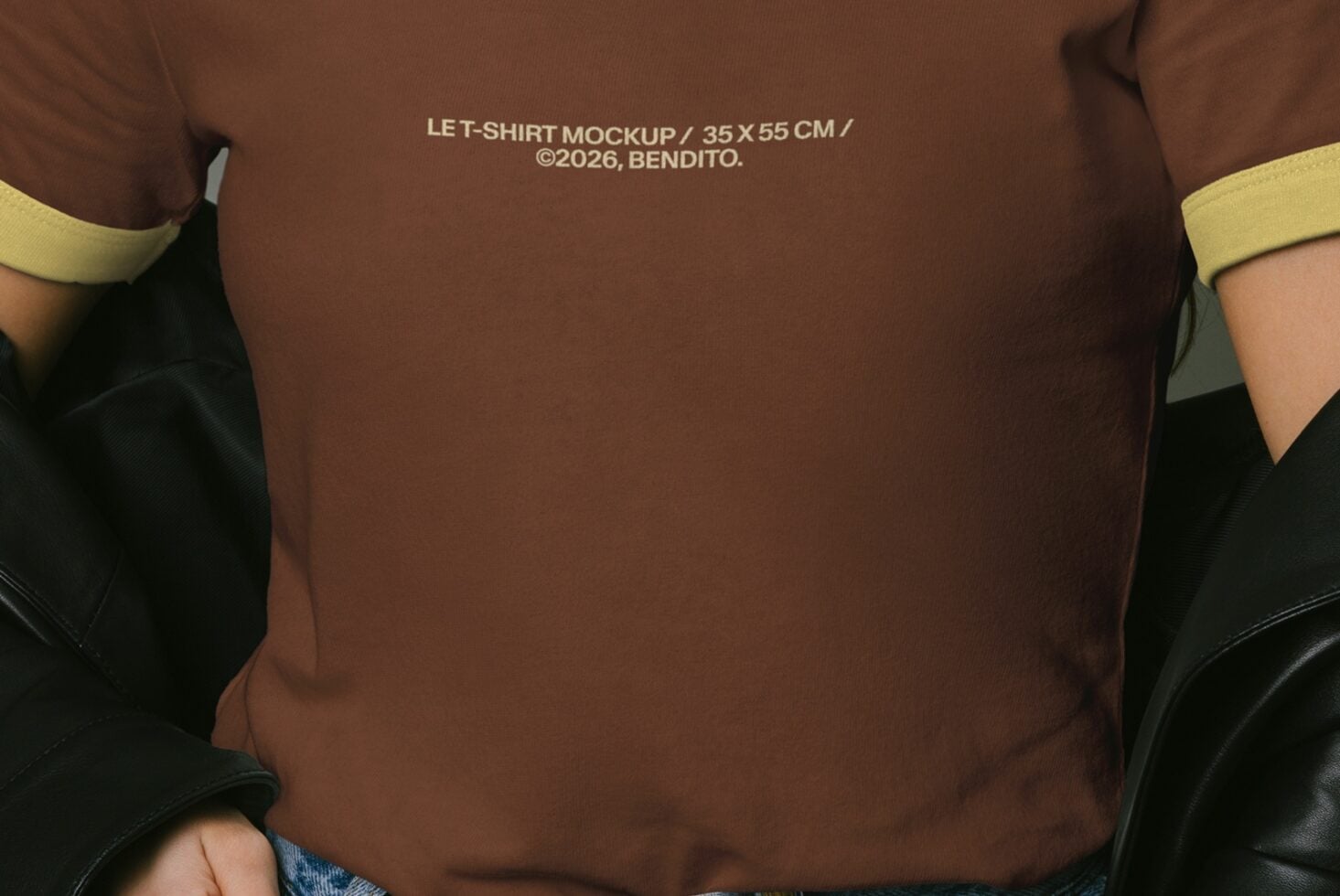 Close up of brown tee chest showing yellow trim at neckline, arms