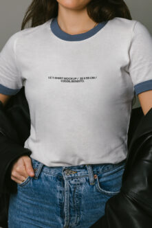 White ringer tee with navy trim worn with blue jeans, black leather jacket
