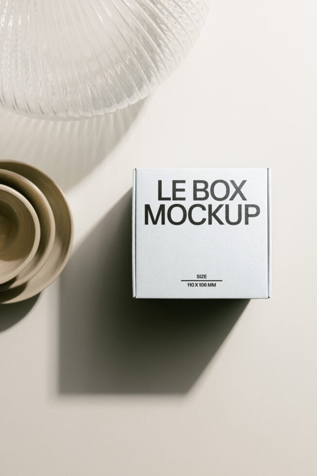 White box mockup in minimalist flat lay alongside stacked natural ceramic dishes