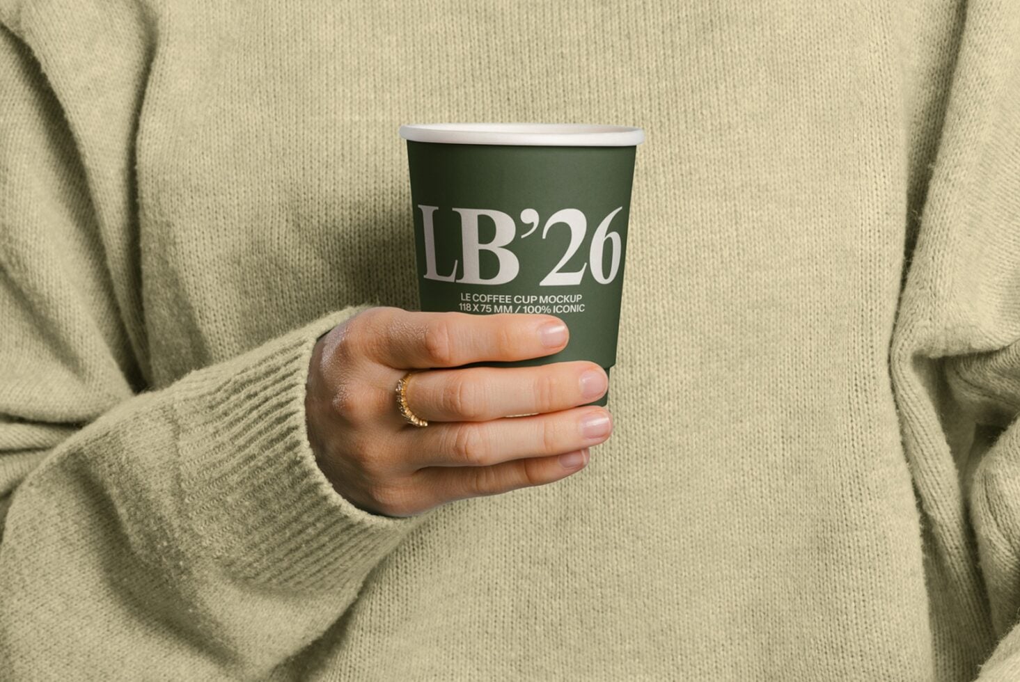 Close up of hands holding dark green paper coffee cup with LB26 label