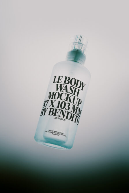 Frosted body wash bottle with spray nozzle floating against soft gradient background