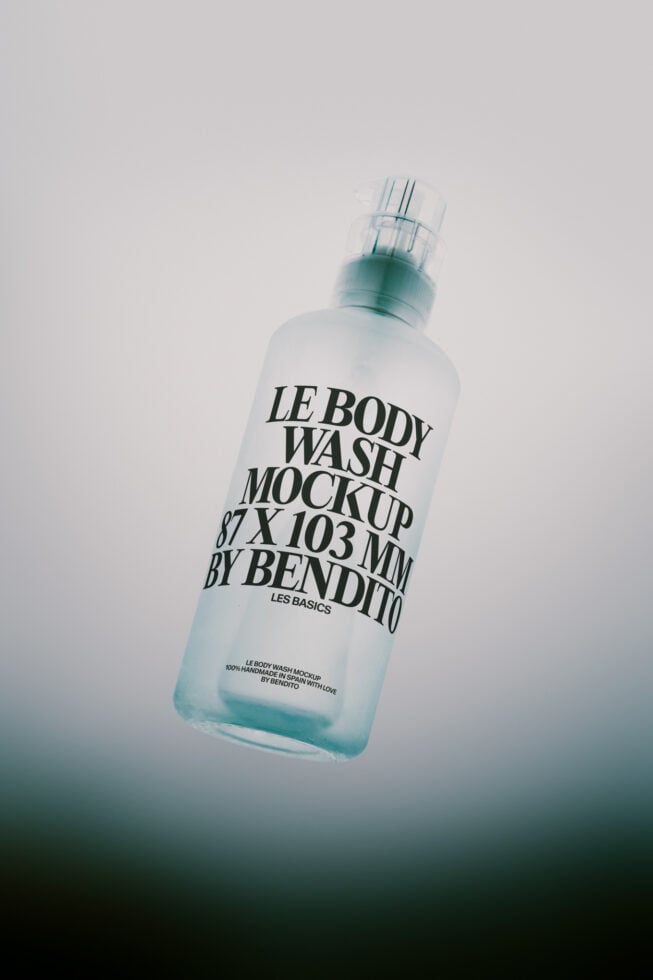 Frosted body wash bottle with spray nozzle floating against soft gradient background
