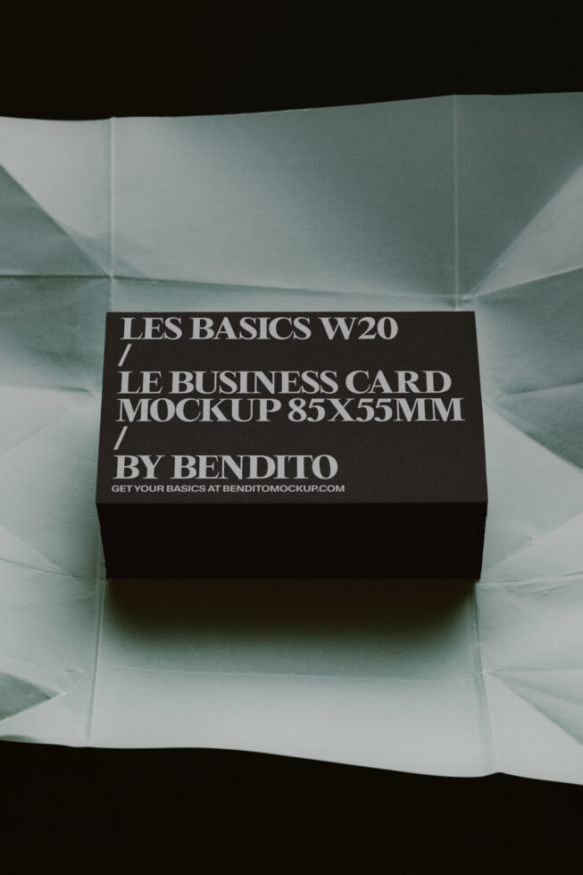 Black business card mockup 85x55mm sitting on folded sage green paper with geometric folds