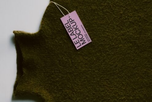 Pink hang tag on chunky olive wool fabric with natural folds