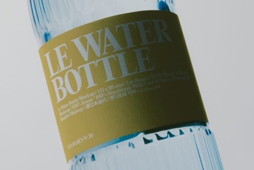 Water bottle with olive label showing "Le Water Bottle" text in white serif font, blue cap, multilingual copy visible