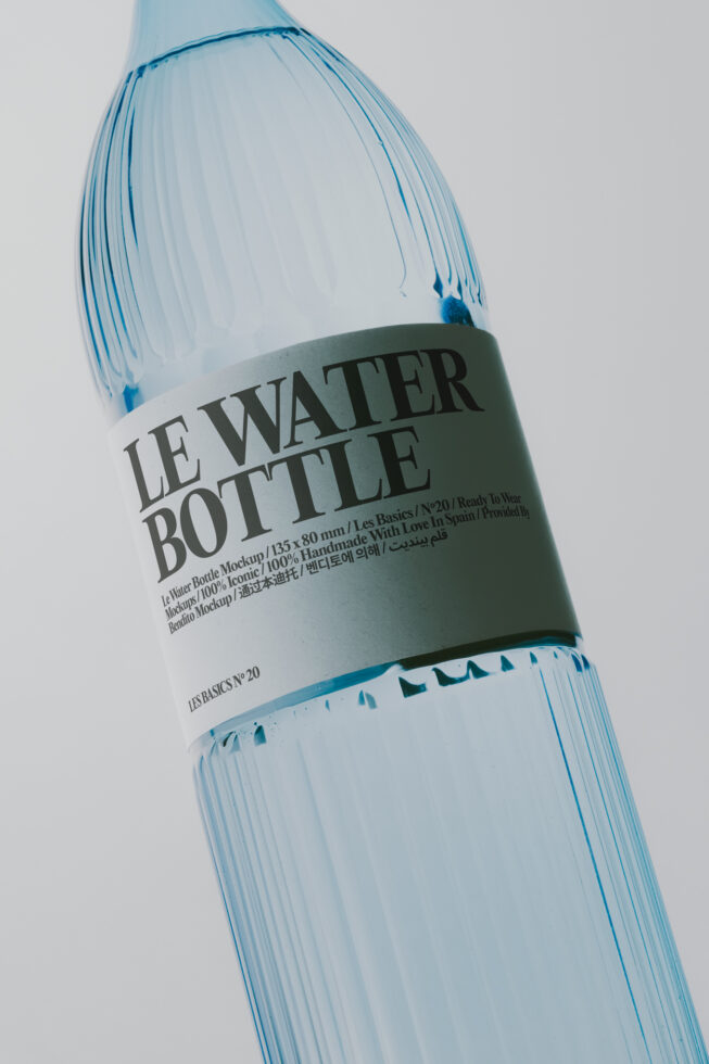 Frosted water bottle with sage green label showing multilingual text on clean white background