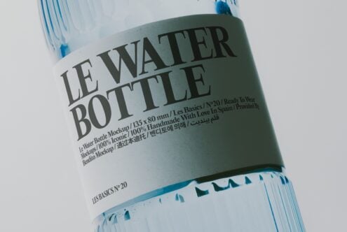 Water bottle mockup with sage green label, multilingual text, blue accent details on white bottle