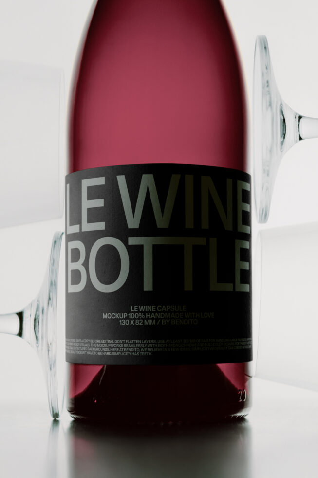 Wine bottle mockup with black label, burgundy liquid, glass positioned at angle