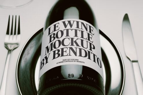 Wine bottle with curved label mockup styled on formal place setting with fork, knife, plate