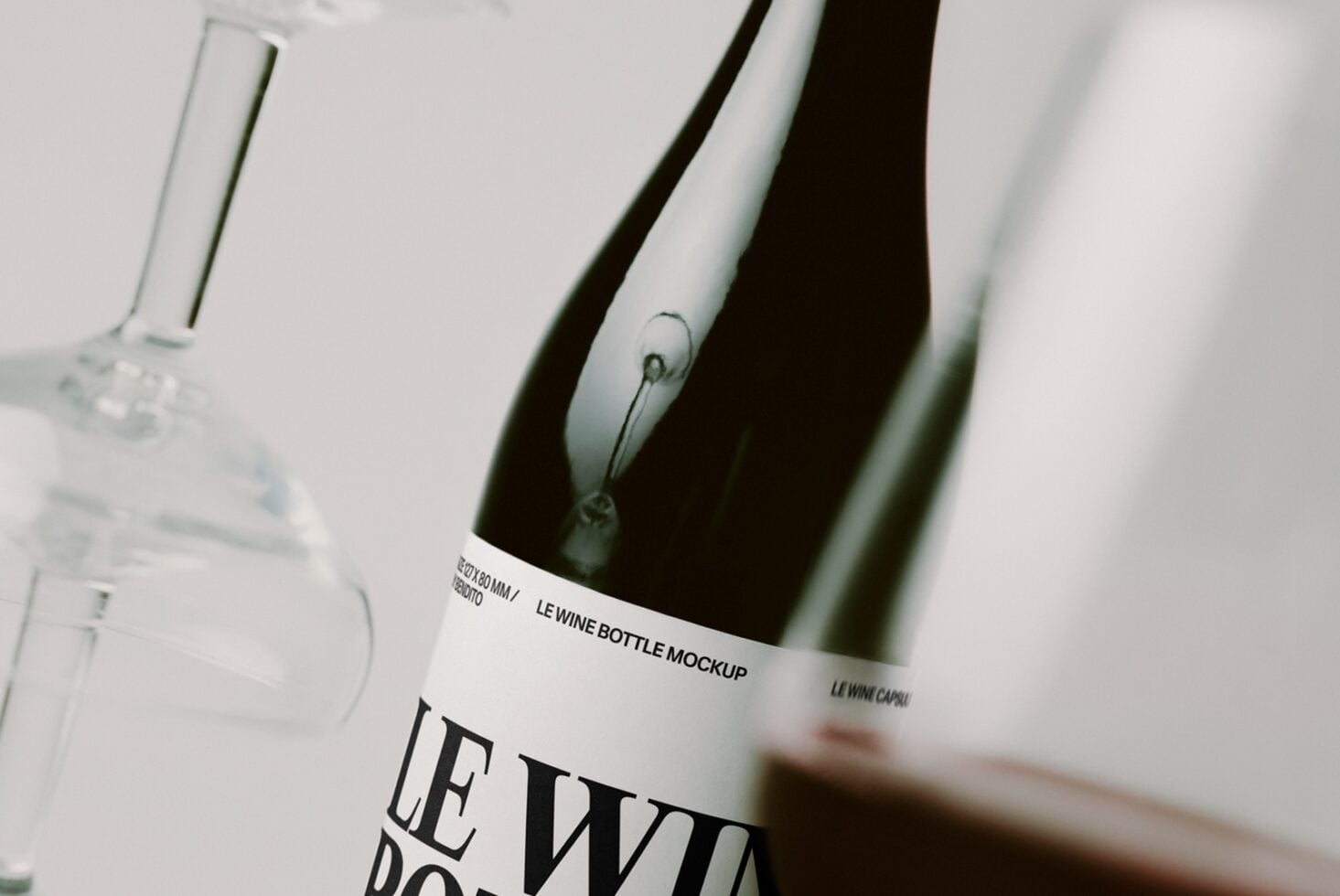 Close-up of wine bottles with white labels showing minimal branding on neutral background