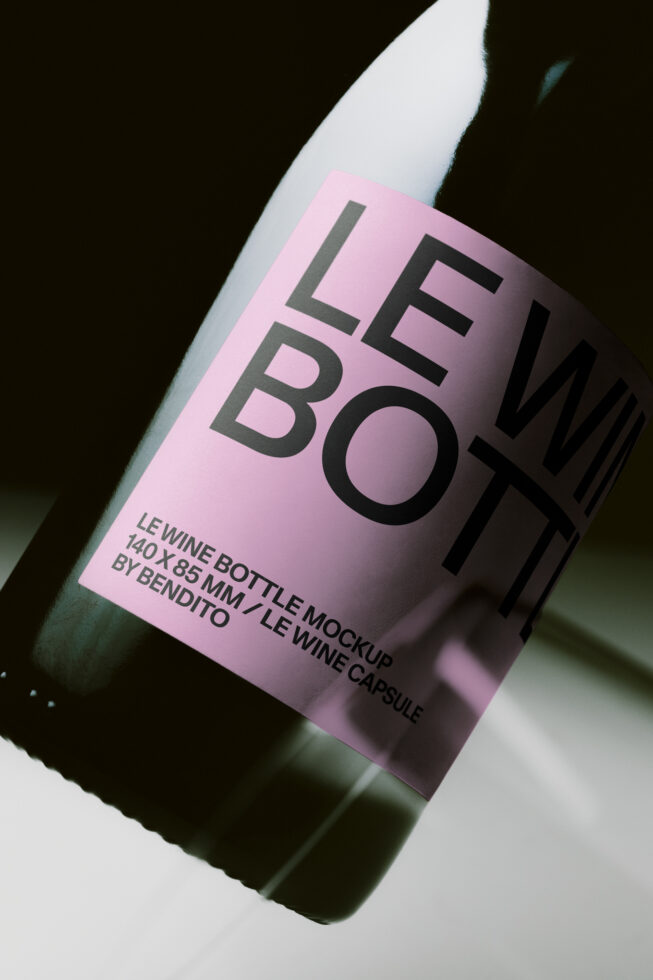 Wine bottle mockup with pink label showing bold typography on angled white bottle against dark background