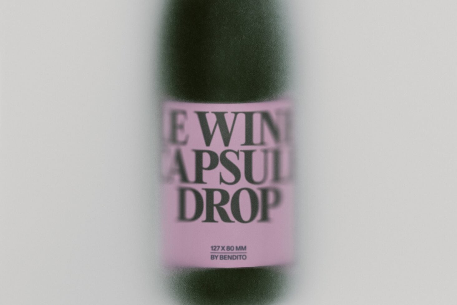 Blurred wine bottle with pink label showing "LEWIN APSULI DROP" text by Bendito