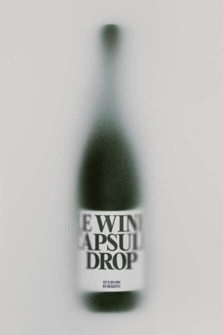 Blurred wine bottle mockup with white label reading "Ewin Apsuit Drop" on neutral background