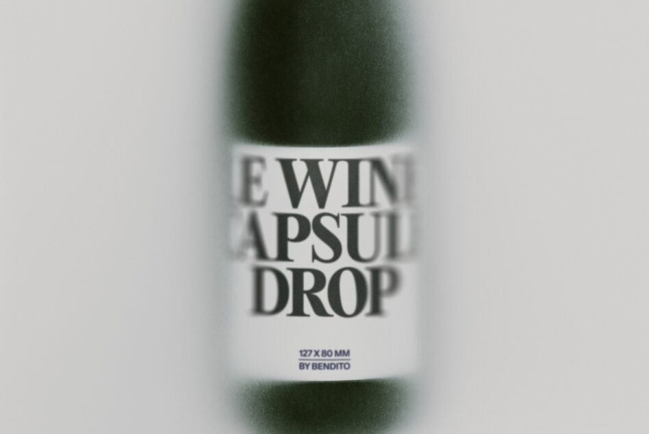 Close-up of skincare bottle label reading "SERUM CAPSULE DROP" with specs listed below, blurred green bottle behind
