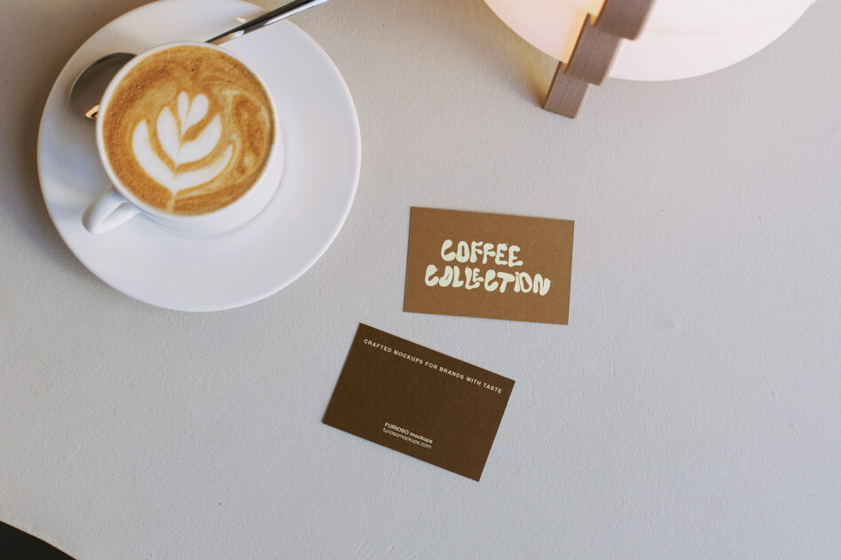 Latte with latte art next to business cards for coffee collection brand