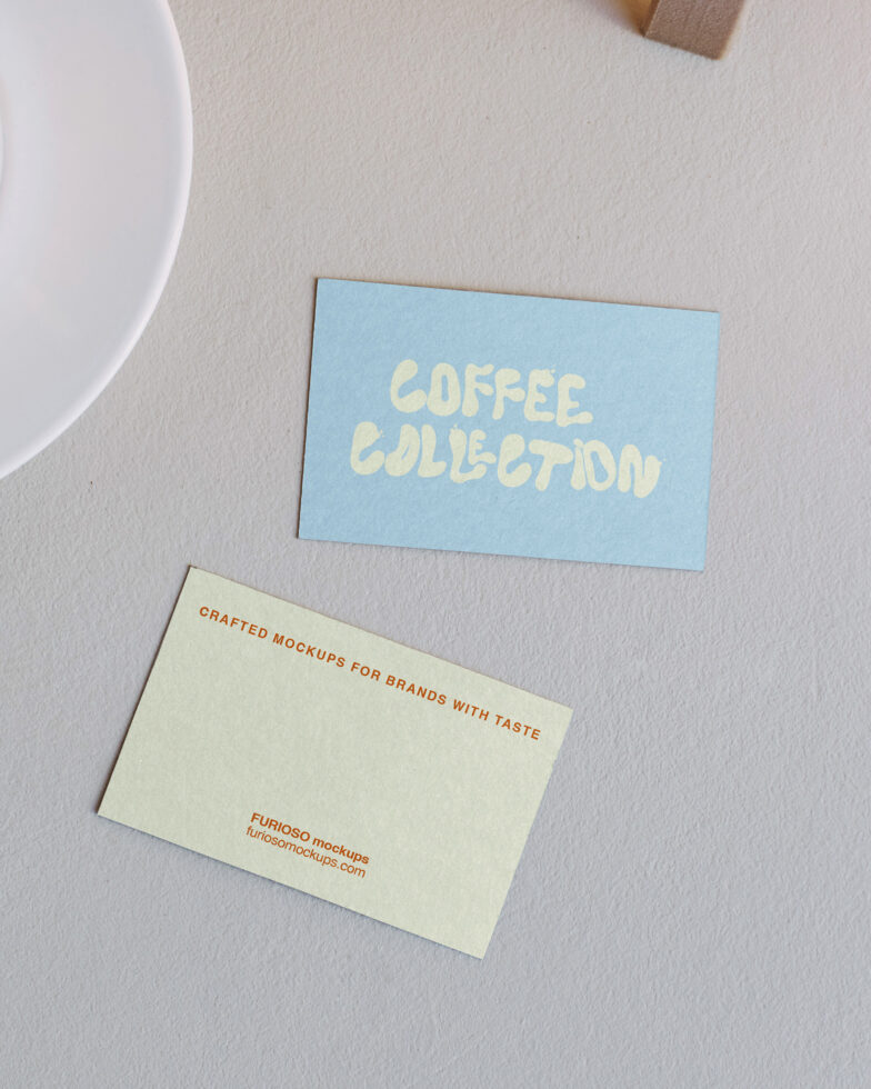 Business cards laid flat blue card with cream text coffee collection branding