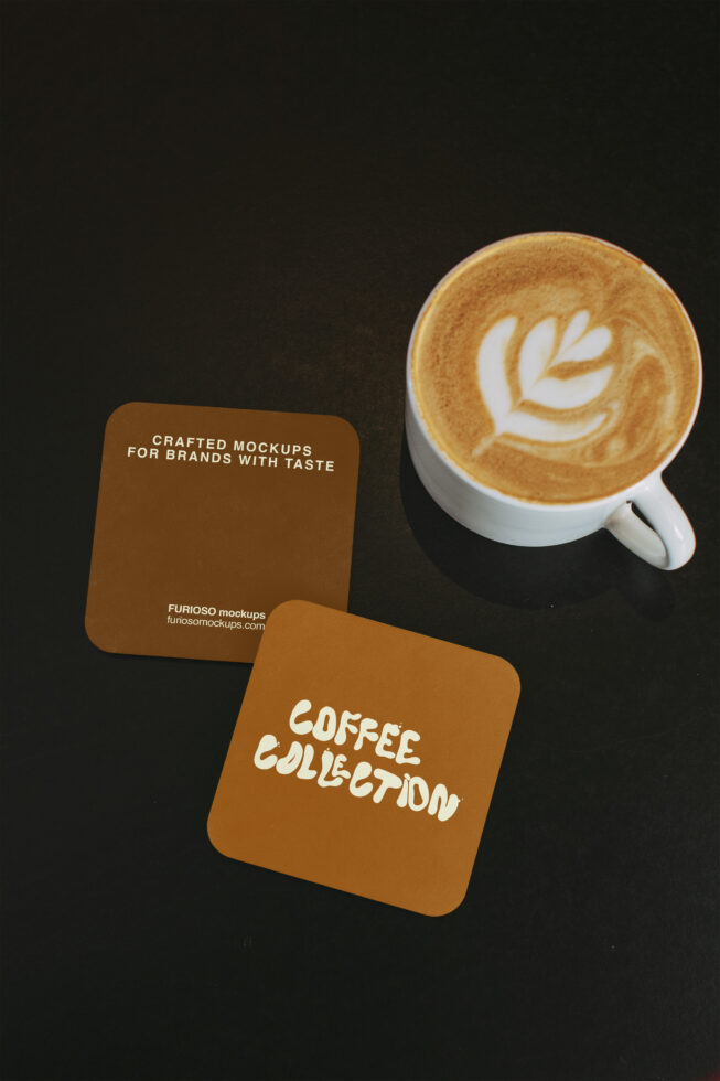 Brown, mustard coasters beside cappuccino with latte art on dark backdrop
