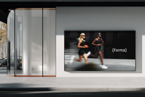 Store interior with mounted screen showing athletes running with Forma logo
