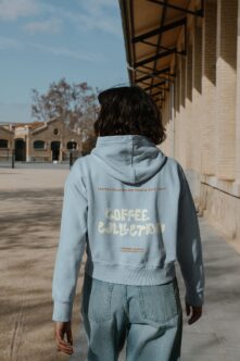 Light blue hoodie back view worn outdoors in urban plaza