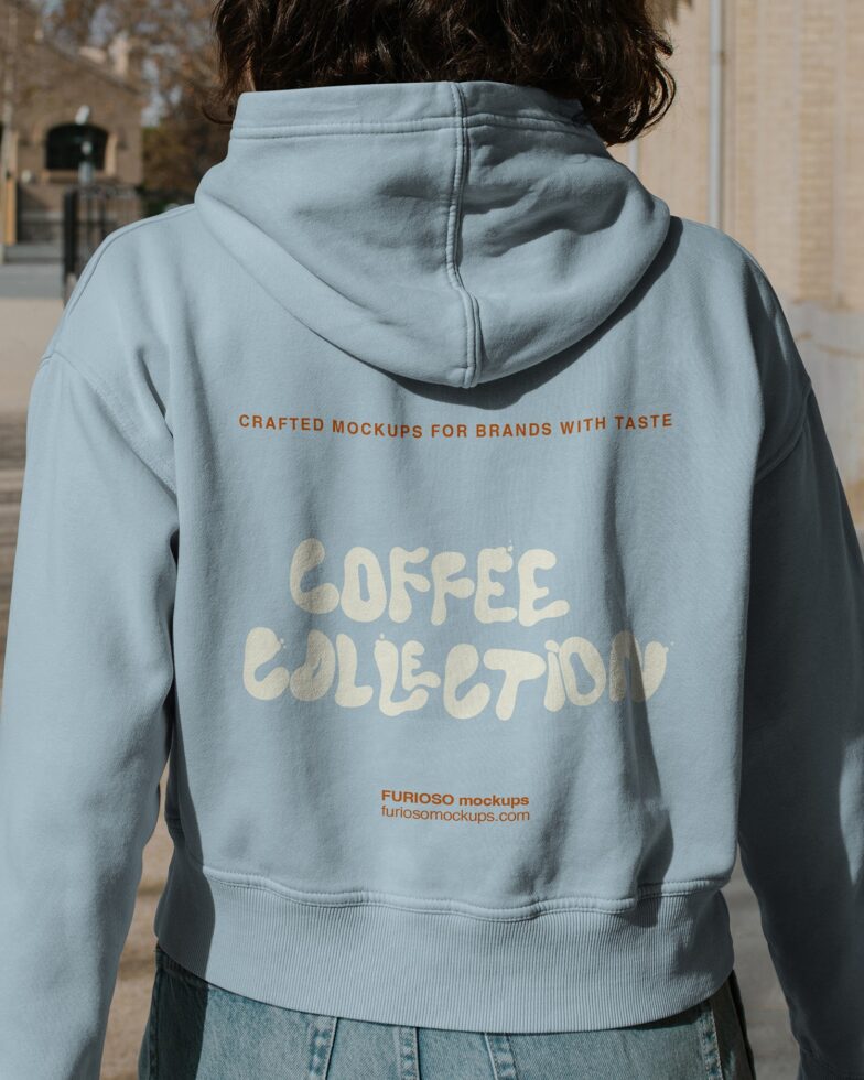 Light blue hoodie back view with Coffee Collection design in outdoor setting