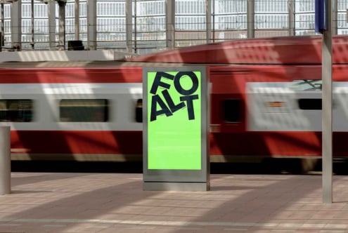Bright neon green poster mockup on street billboard with moving train blurred behind it
