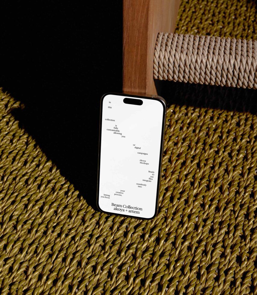 iPhone mockup displaying Beam Collection website with minimalist text layout on mustard fabric with wooden chair