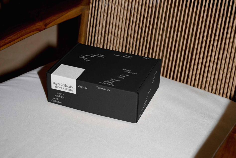Black luxury box mockup with white label sitting on marble table, wood paneling behind
