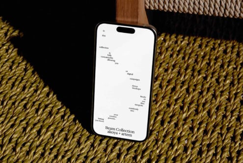 iPhone mockup displaying Beam Collection text layout on woven textile background with wood accents
