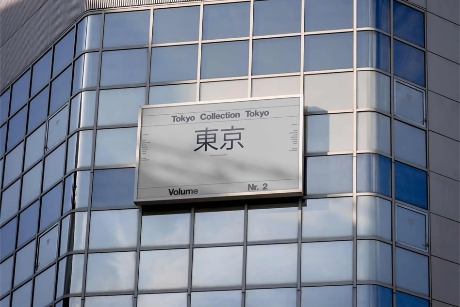 Modern billboard mockup mounted on curved glass building facade with Tokyo Collection design