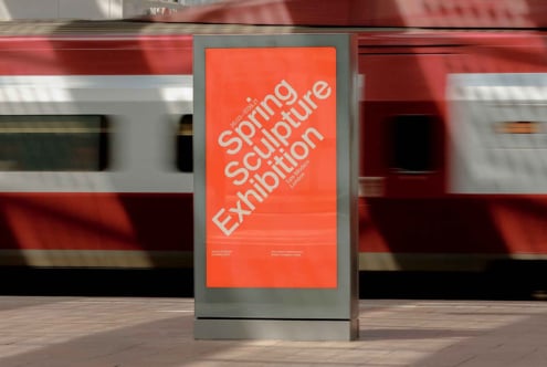 Bright orange poster mockup on street billboard with moving train blurred behind