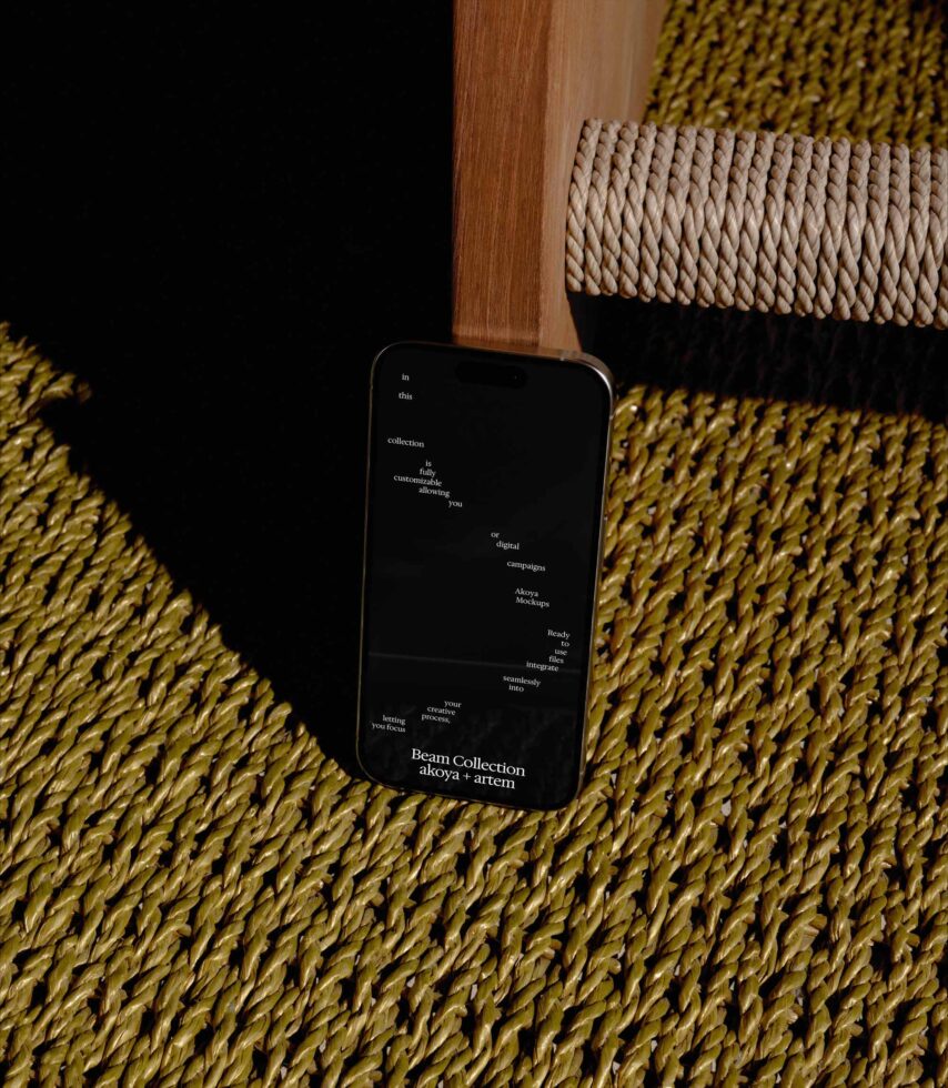Smartphone mockup on mustard knit fabric with wooden chair leg, displaying Beam Collection typography layout