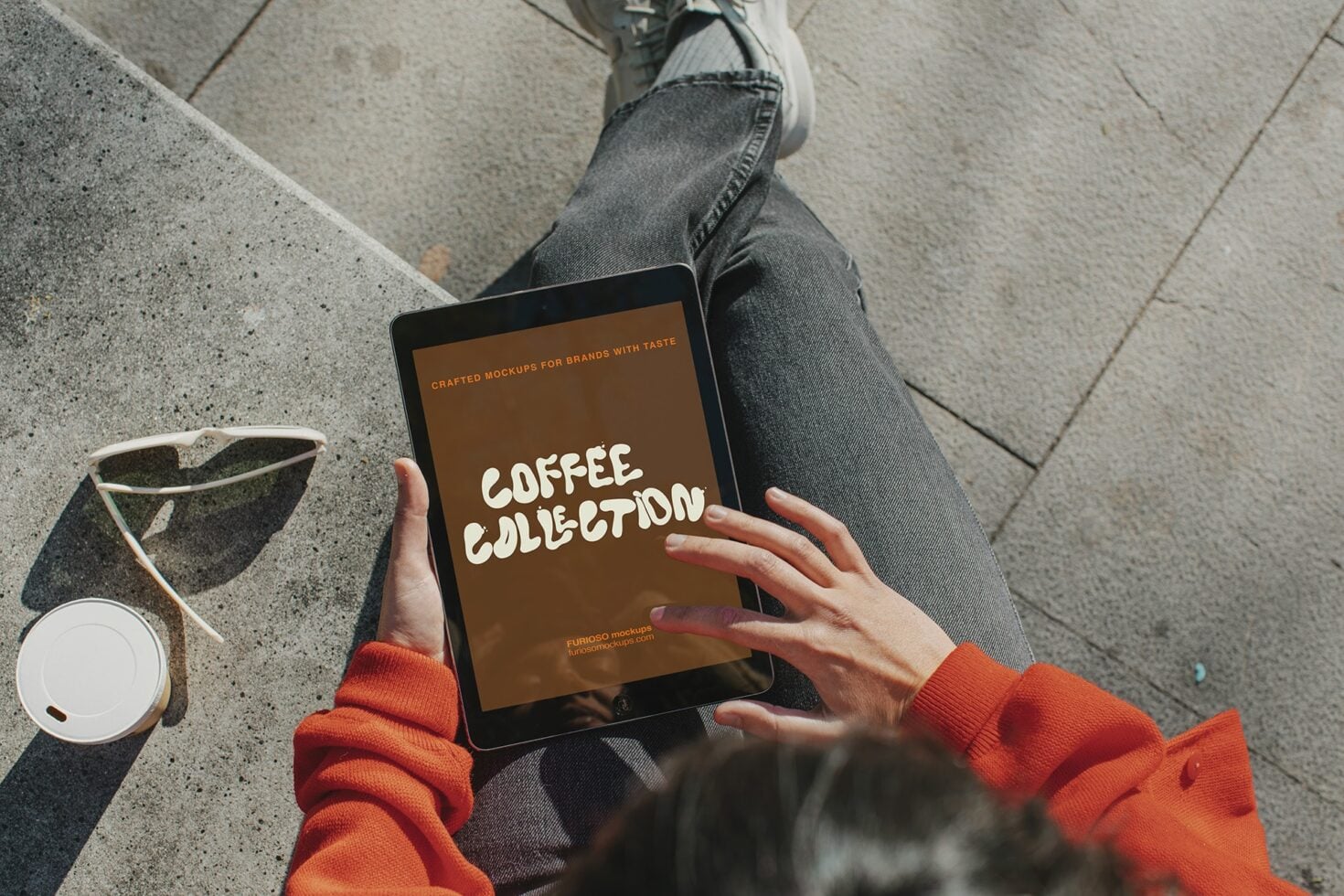 Digital tablet displaying coffee collection mockup held by person outdoors
