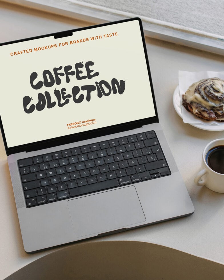 Laptop displaying coffee collection mockup surrounded by cappuccino mug cinnamon roll