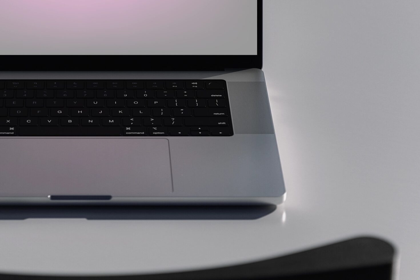 Silver laptop angled showing keyboard detail on neutral background with soft shadows