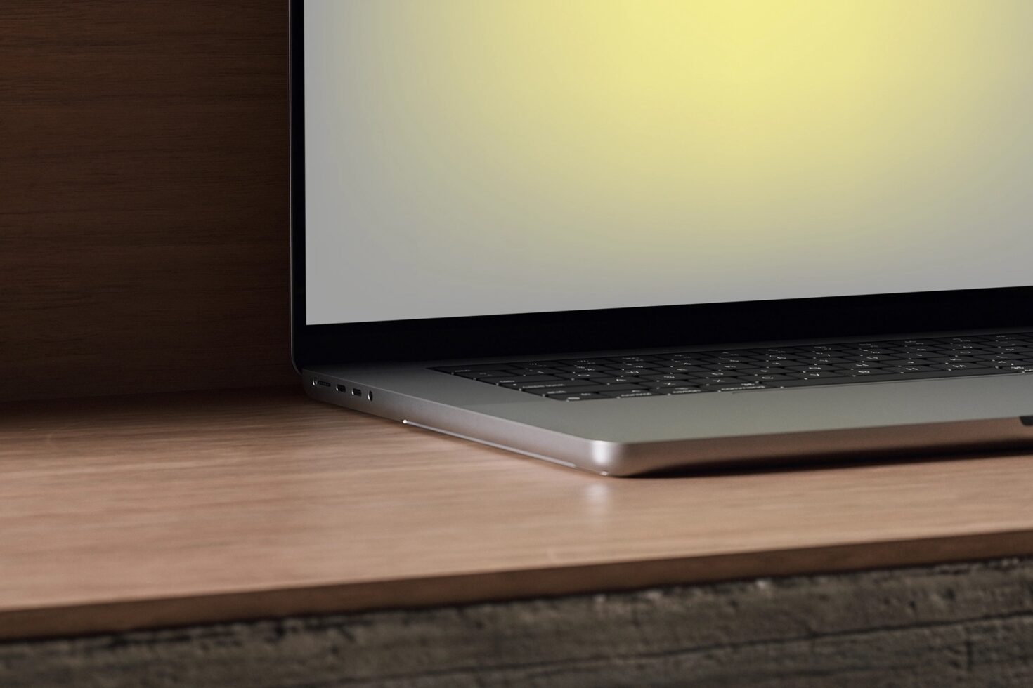 Laptop on wooden desk with blank cream screen, dark wood panel in background