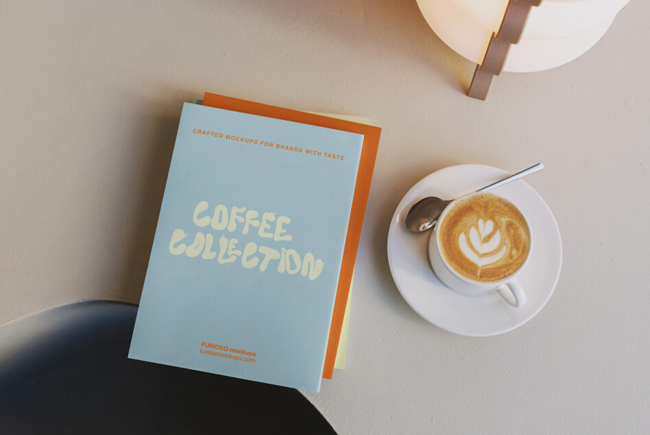 Blue Coffee Collection notebook stacked with orange spine next to latte cup with latte art