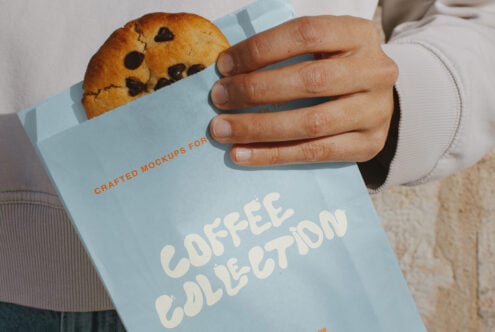Light blue takeout bag holding cookie, displaying Coffee Collection text in cream lettering