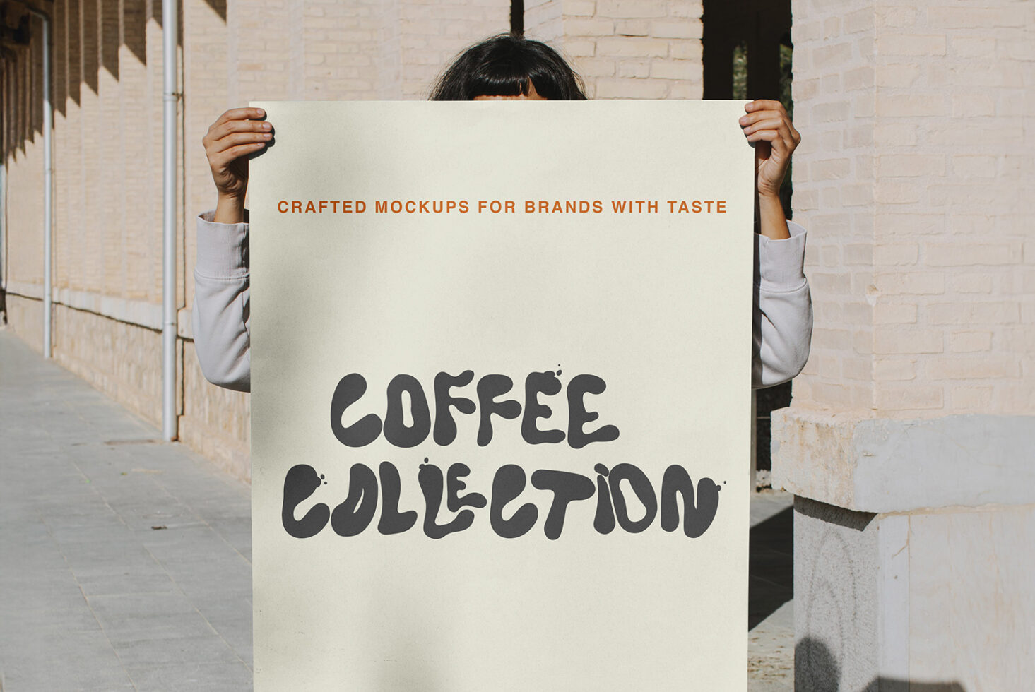 Person holding cream poster with dark text saying Coffee Collection outdoors