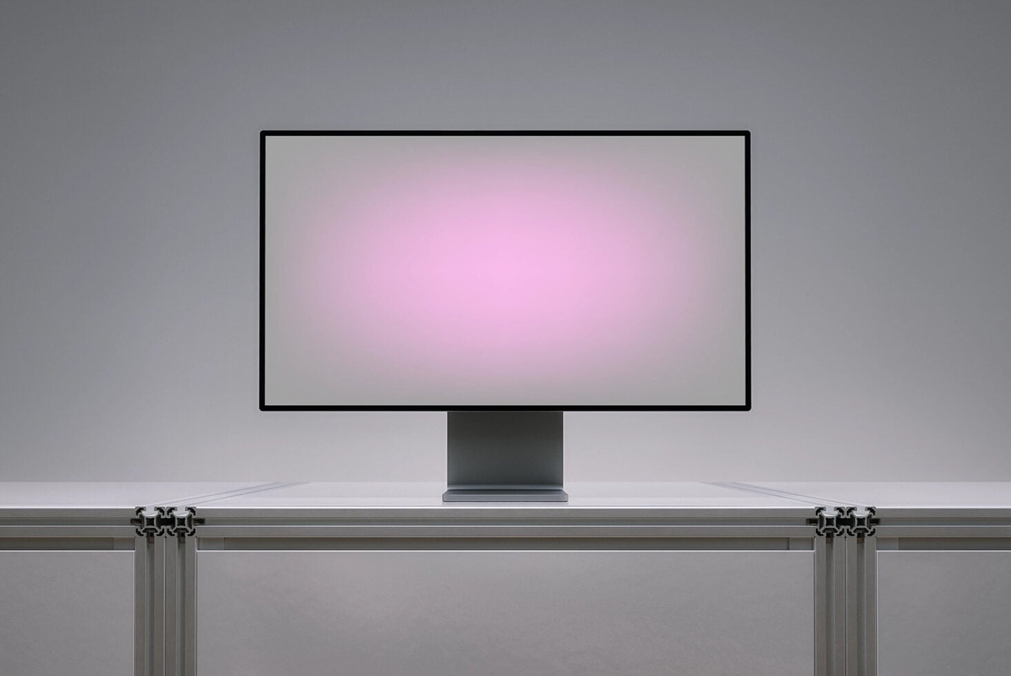 Desktop monitor mockup on desk with pink gradient screen display