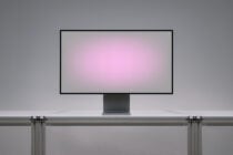 Desktop monitor mockup on desk with pink gradient screen display
