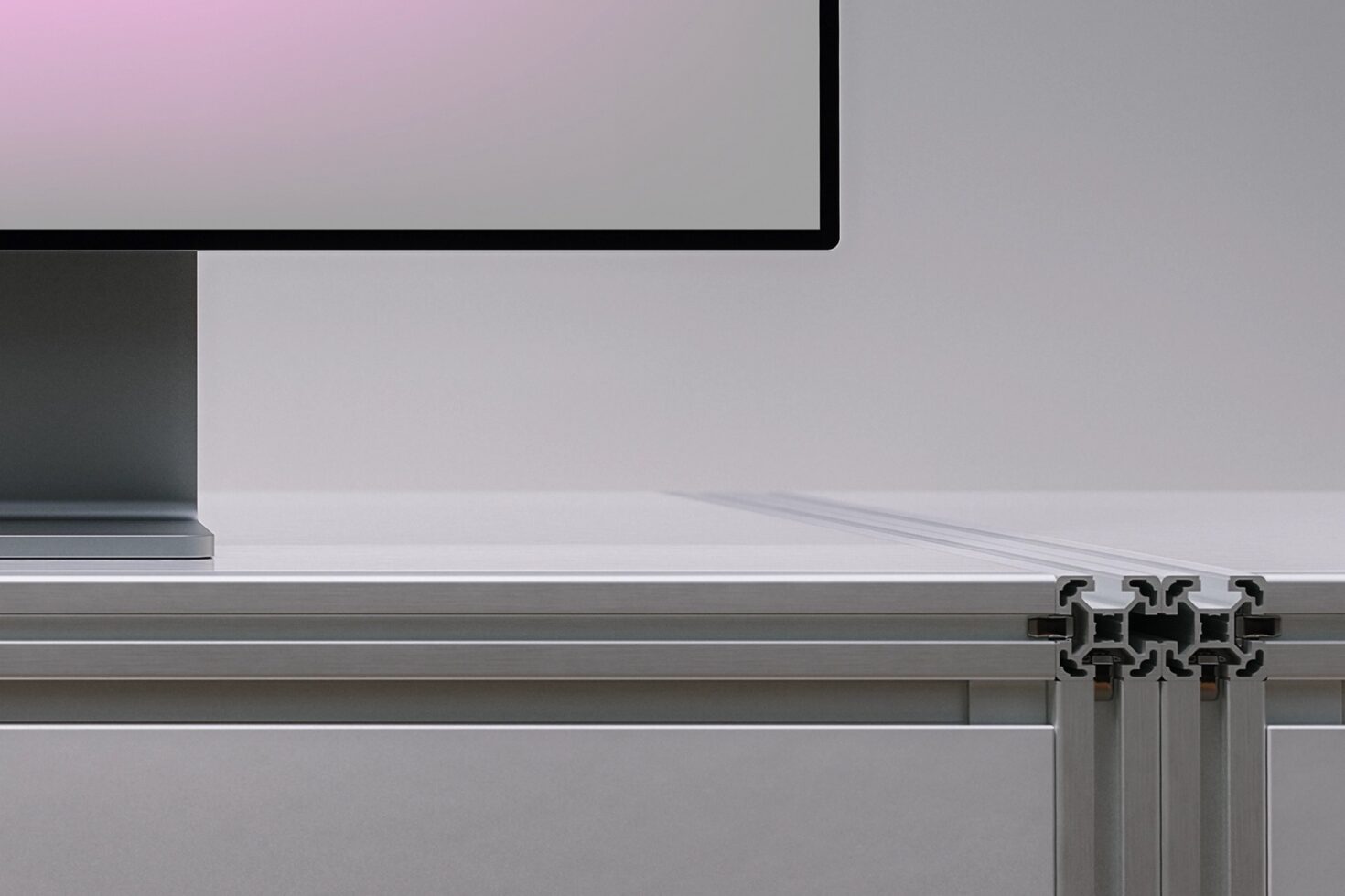 Minimalist monitor mockup with pink gradient, silver aluminum frame, metallic curtain rod detail below