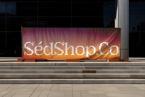 Stretched fabric banner on building exterior with pixelated typography design