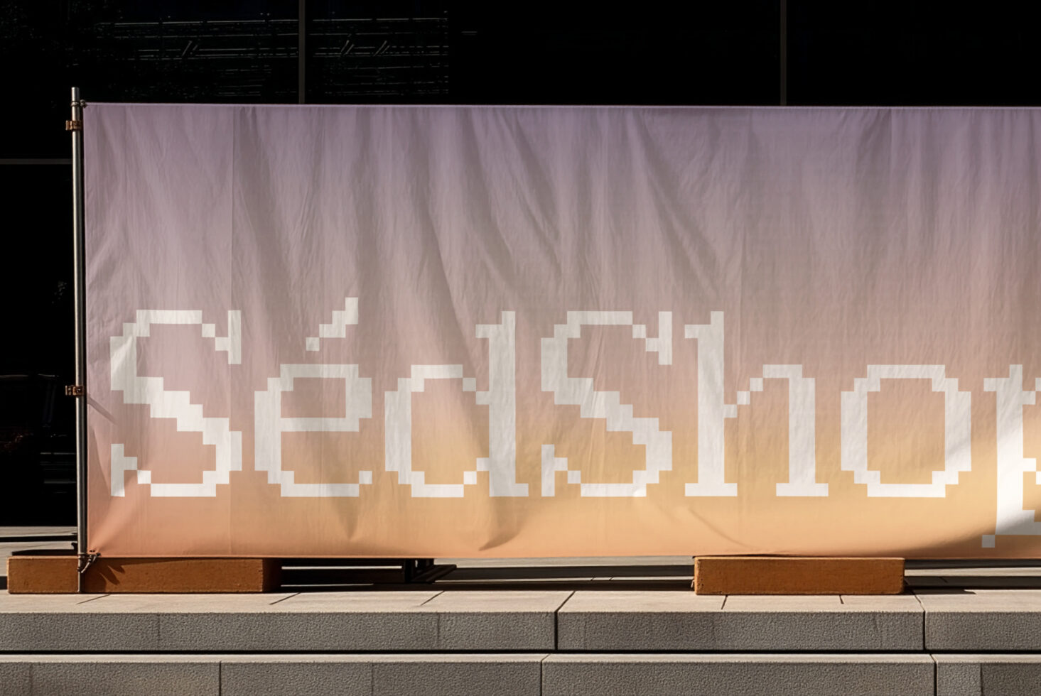 Storefront window banner with pixelated serif text on gradient fabric