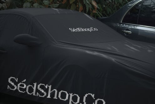 Black car windshield cover mockup with pixelated retro font logo displayed