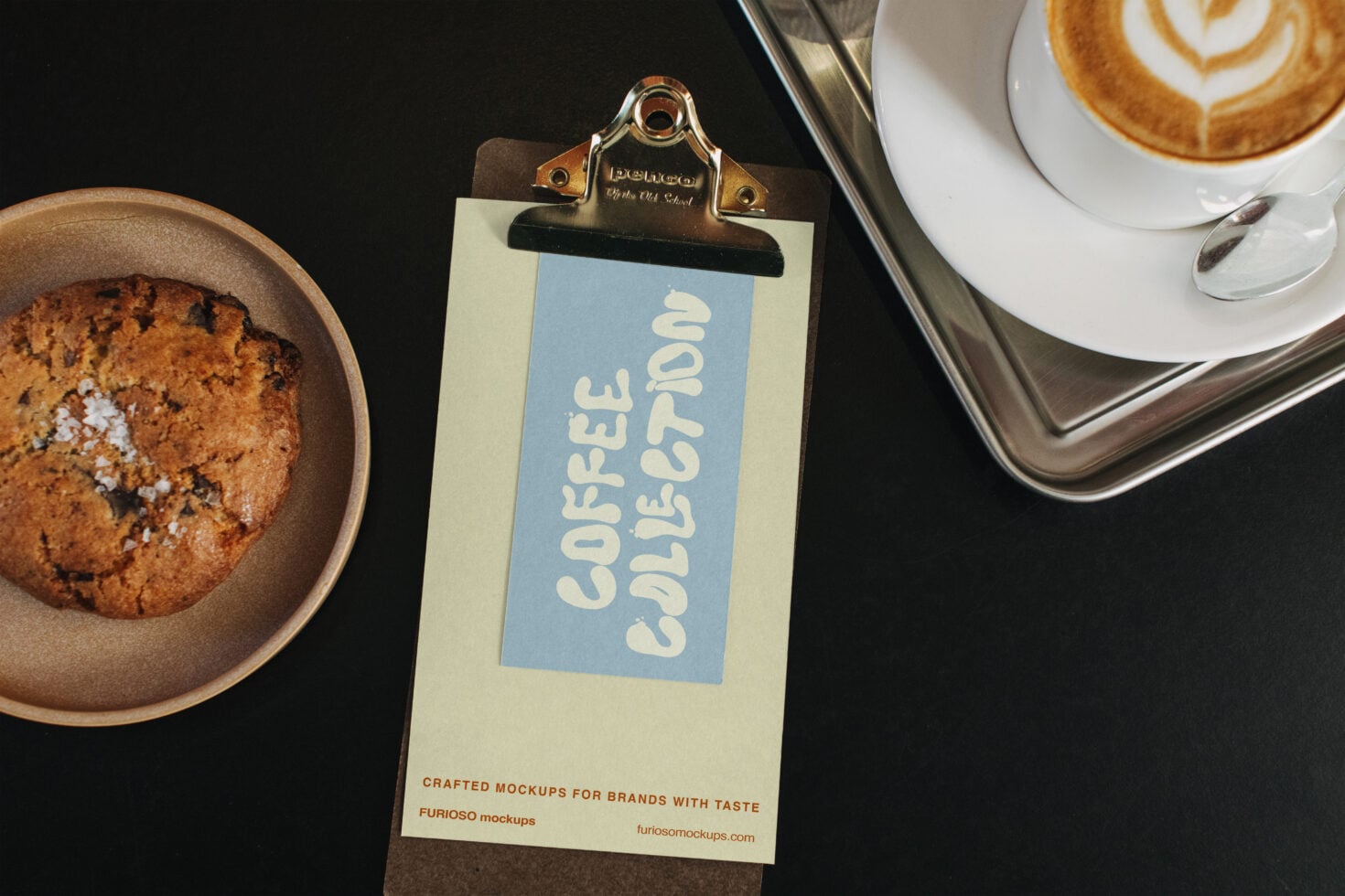 Styled overhead shot of clipboard with blue label between coffee cup latte on right, pastry bowl left