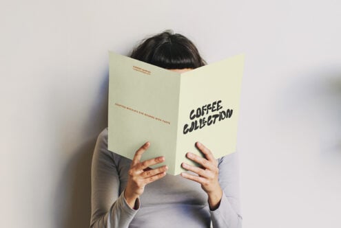 Person holding open cream colored folded brochure with Coffee Collection text visible